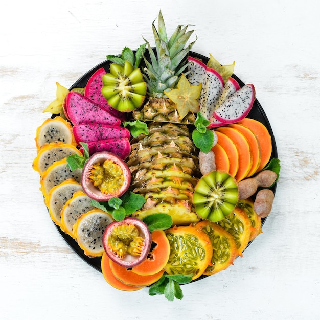 A plate of sliced tropical fruit Top view Free space for text