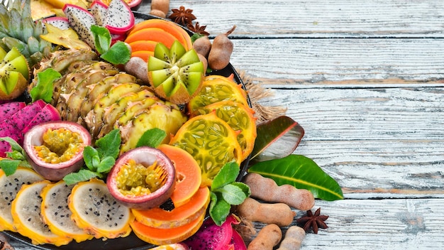 A plate of sliced tropical fruit. Top view. Free space for text.