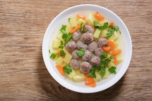 Photo plate of soup with meatballs top view