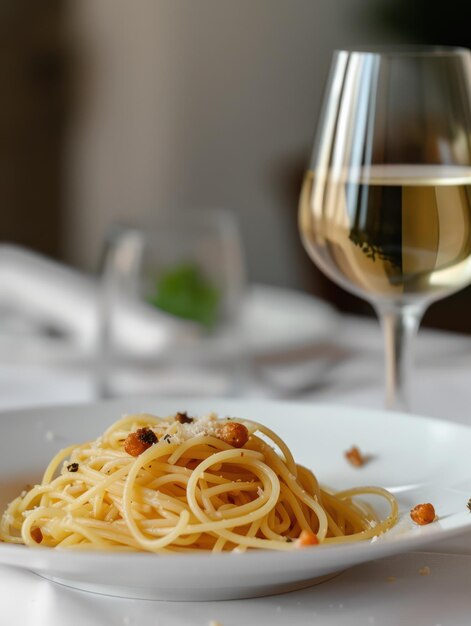 Foto plate spaghetti pasta en een glas witte wijn op een tafel