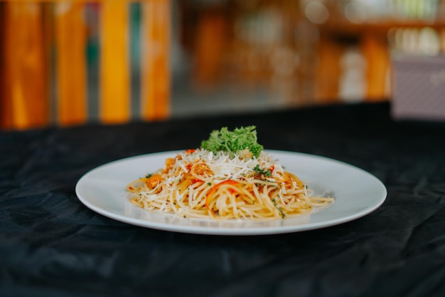 A plate of spaghetti with a green herb on it