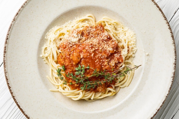 A plate of spaghetti with a red sauce and parmesan cheese.