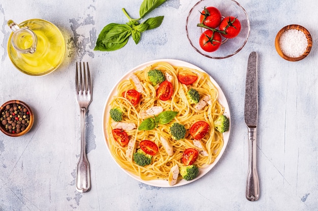 Plate of spaghetti with tomato, broccoli and chicken