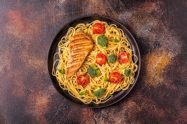 Foto piatto di spaghetti con pomodoro, broccoli e pollo