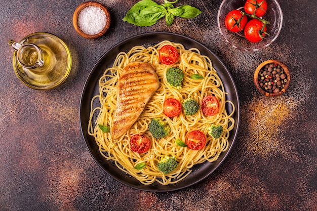 Plate of spaghetti with tomato, broccoli and chicken