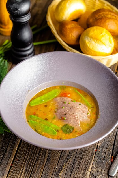 Foto su un piatto, zuppa di gulasch piccante, con fettine di carne, con piselli, verdure