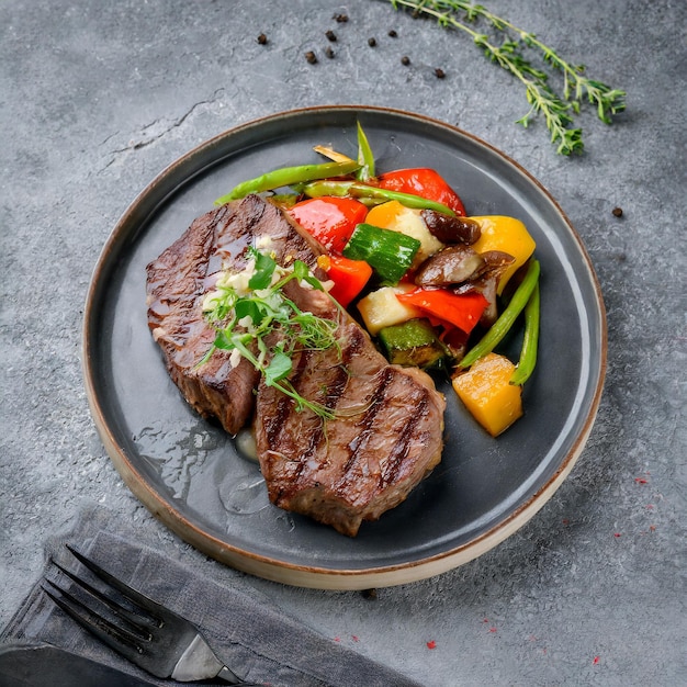 Foto un piatto di bistecca con verdure su di esso su superficie grigia pietra ai generato