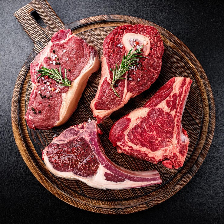 a plate of steaks with a wooden spoon and a wooden spoon