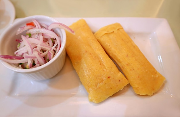 Foto piatto di torte di mais fresche al vapore chiamate humitas, un cibo tradizionale popolare della regione delle ande in perù