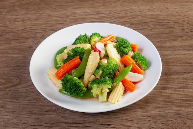 Plate of stir fry vegetables on wooden table