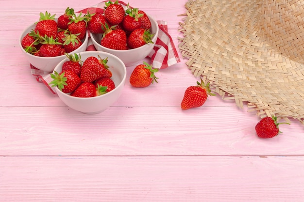 Plate of strawberry on pink wooden background 