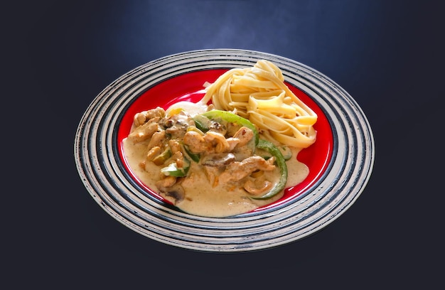 A plate of stroganoff with white sauce and spaghetti