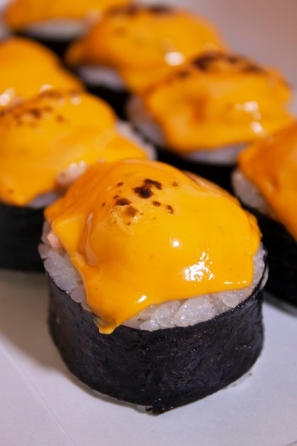 Photo a plate of sushi with cheese on top