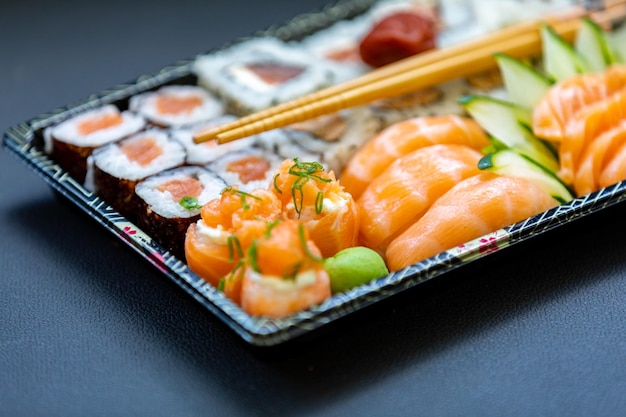 A plate of sushi with a green vegetable on it