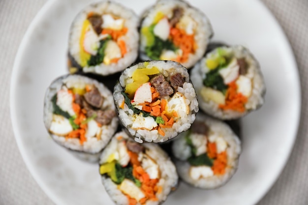 A plate of sushi with meat and vegetables on it