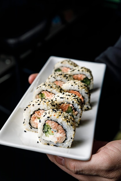 A plate of sushi with a sesame seed roll on it