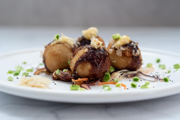 Foto un piatto di takoyaki su un tavolo di marmo