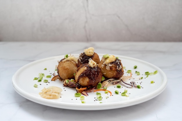 A plate of takoyaki over a marble table