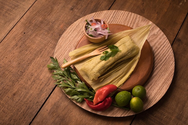 A plate of tamales with a bowl of cilantro and limes on it