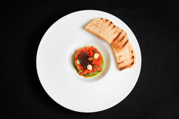 Plate of tartare on black background