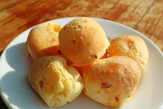 Plate of Tasty Brazilian Cheese Breads or Pao de Queijo Served on Wooden Table