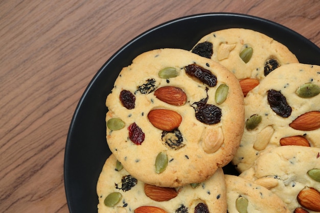 Plate of Tasty Homemade Almond and Raisin Cookies on Wooden Table