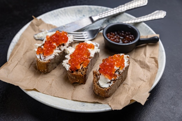 A plate of toasts with red caviar