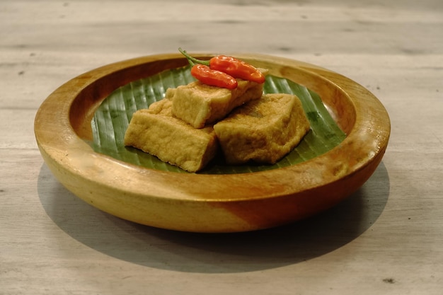 A plate of tofu with a red pepper on top