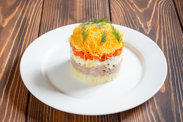 Plate of traditional russian salad Mimosa with fish