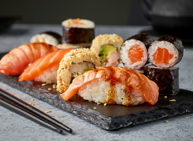 Photo plate of various sushi on restaurant table, selective focus