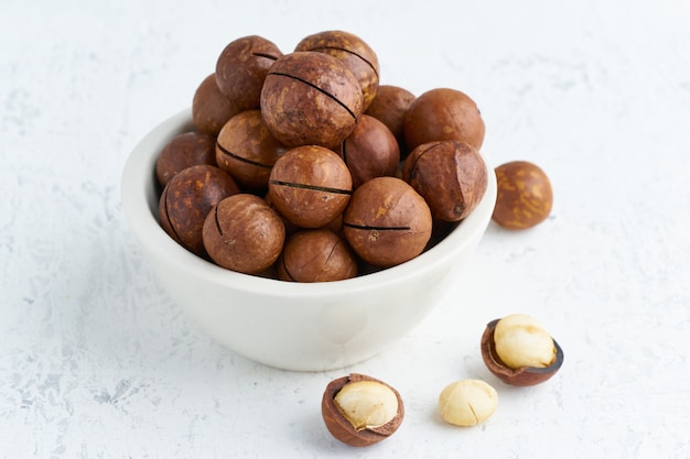 Plate with almonds in endocarp, whole and chopped open nuts in bulk on cutting board