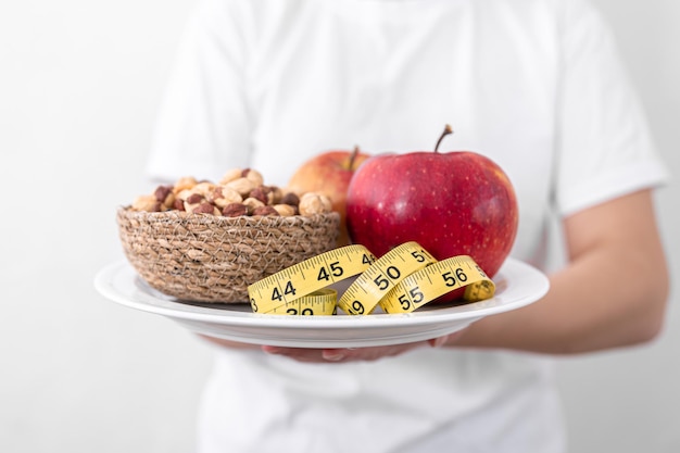 リンゴの実と巻尺の食事療法と健康食品の概念をプレート