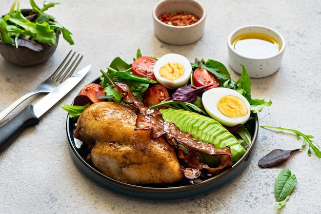plate with baked chicken fillet with bacon fresh vegetables salad