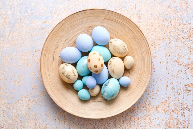 Plate with beautiful Easter eggs on light