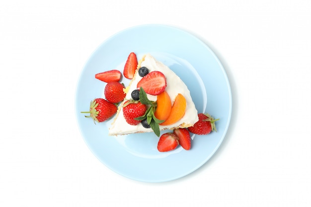 Plate with berry cream cake isolated on white background