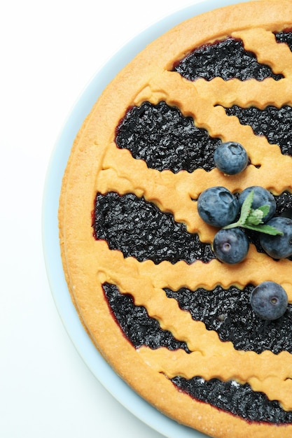 Plate with blueberry pie on white