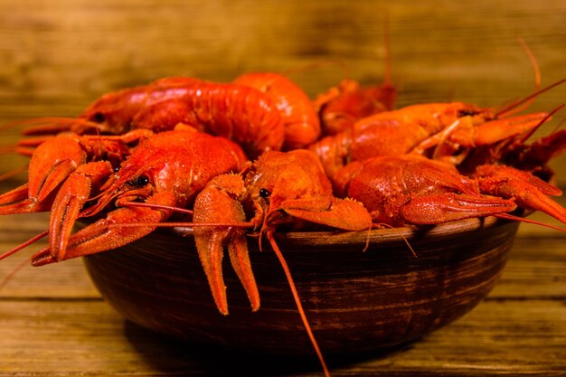 Plate with boiled crayfishes on rustic wooden table