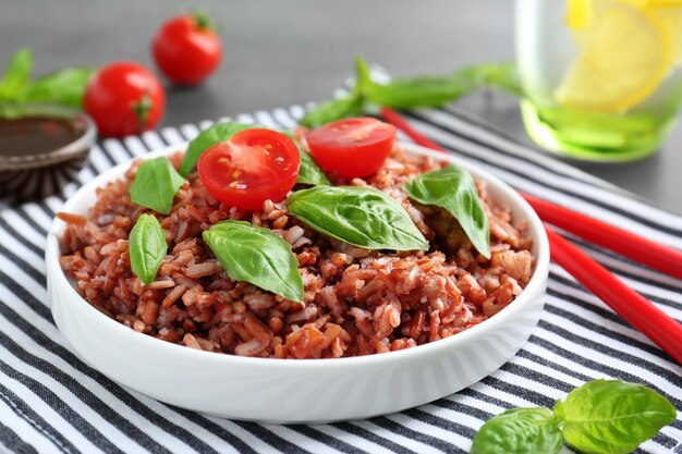 Plate with brown rice on table