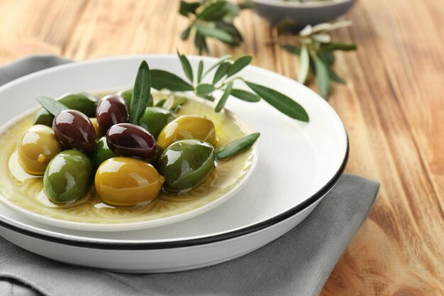 Foto piatto con olive in scatola su tavolo di legno
