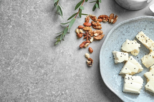 Plate with cheese on grey background