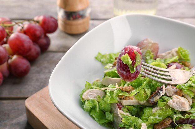 Plate with chicken salad and grapes on table