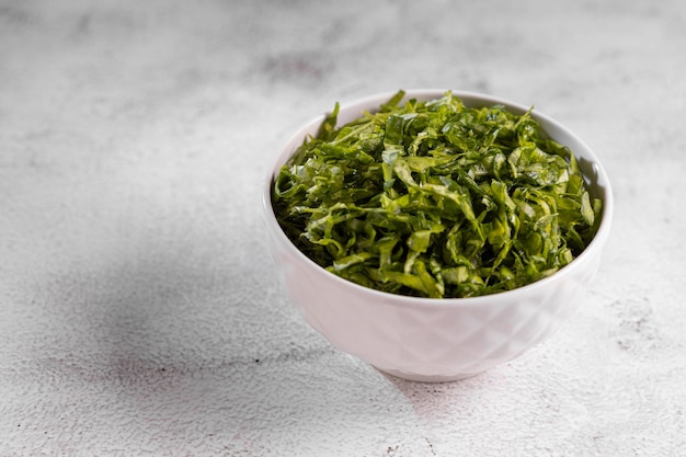 Photo plate with chopped kale leaves green cabbage leaves