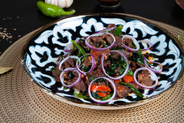 사진 검은색 배경 아시아 요리에 다진 고기와 야채를 곁들인 접시