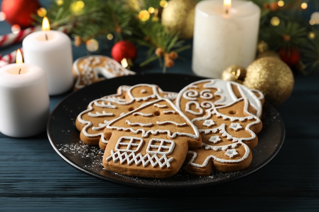 Plate with Christmas cookies, Christmas tree and toys on blue, space for text. Closeup