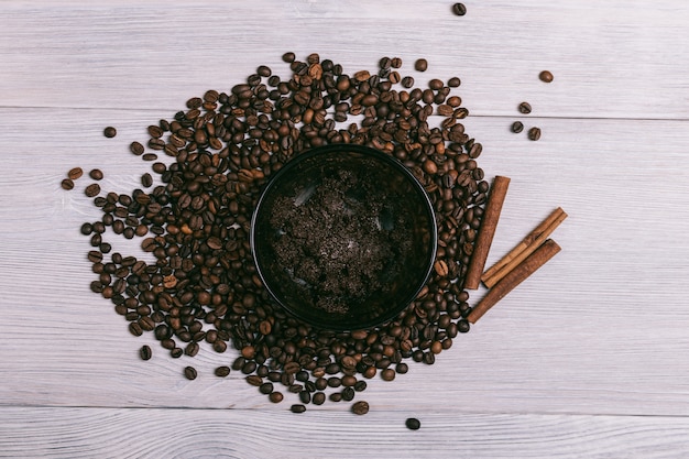 Plate with coffee scrub is on the table among coffee beans