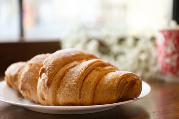 Plate with croissant for breakfast on table closeup