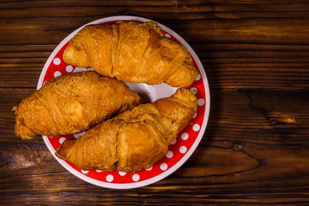 Foto piatto con croissant su un tavolo di legno vista dall'alto