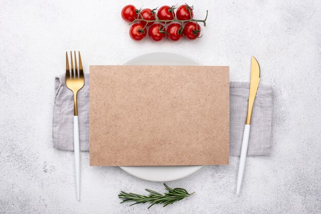 Photo plate with cutlery and tomatoes on table