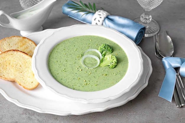 Plate with delicious broccoli cheese soup on table