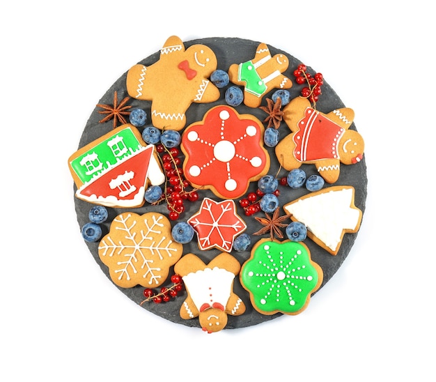 Plate with delicious Christmas cookies on white surface